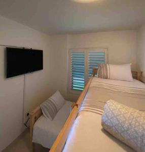a bedroom with a bed and a couch and a flat screen tv at Unobstructed sea view gem (1 Spindrift) in St Francis Bay +24 photos