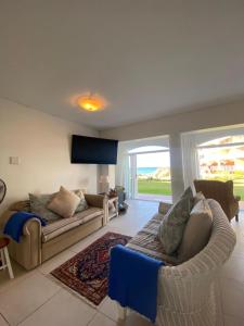 a living room with two couches and a couch at Unobstructed sea view gem (1 Spindrift) in St Francis Bay