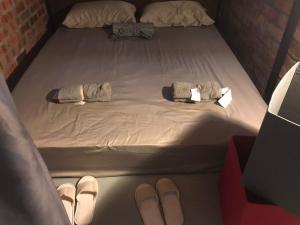 a bed with two clothes and shoes on it at OA ThE FACTORY AT BUKIT BINTANG in Kuala Lumpur