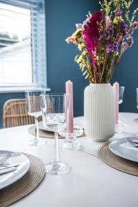 a white table with a vase of flowers on it at Southern - Bracklesham Bay in Chichester