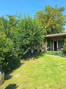 ein Haus mit einem Garten mit einem Baum davor in der Unterkunft Szalupa H9 in Zakroczym