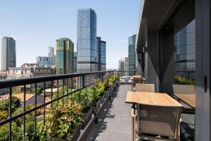 een balkon met een tafel en uitzicht op de stad bij Ramada Encore by Wyndham Istanbul Sisli in Istanbul