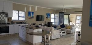Una cocina y una sala de estar con un sofá y una mesa. en Gorgeous St Francis Canal House, en St Francis Bay