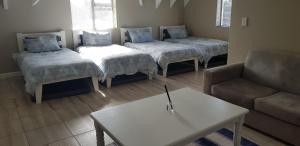 sala de estar con 4 camas y sofá en Gorgeous St Francis Canal House, en St Francis Bay