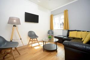 a living room with a black couch and a table at Stylish and spacious Southampton stay in Southampton