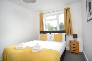a bedroom with a yellow and white bed and a window at Stylish and spacious Southampton stay in Southampton