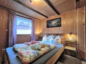 een slaapkamer met een bed in een houten kamer bij Ferienwohnung Mohnkopf in Jerrishoe