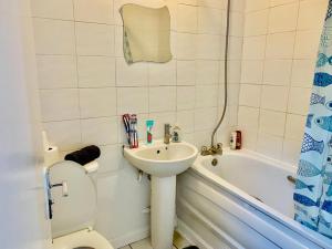 a bathroom with a toilet and a sink and a tub at Spacious One bedroom apartment Edgeware Road Central London in London