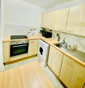 a small kitchen with a sink and a dishwasher at Spacious One bedroom apartment Edgeware Road Central London in London