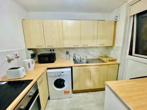 a kitchen with a sink and a washing machine at Spacious One bedroom apartment Edgeware Road Central London in London