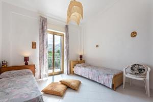 a bedroom with two beds and a window at Casa Vacanze Zina in Altavilla Milicia