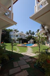 un cortile con piscina e una casa di Richmonde Ananta Elite Luxurious Villa & Apartments,Goa a Baga