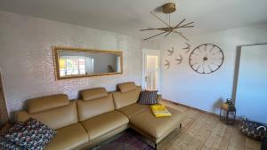 a living room with a couch and a clock on the wall at Roßtrappenblick in Thale
