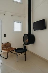 a living room with a tv and a chair and a table at Ponte Suites in Antirrio