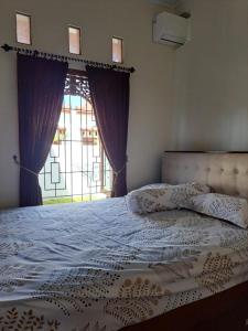 una camera da letto con un grande letto e una finestra di Omah Medina a Klaten