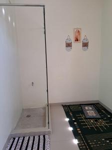 um quarto com uma porta de vidro e um tapete no chão em Omah Medina em Klaten