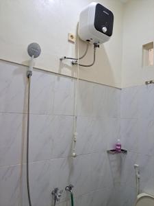 bagno con doccia e asciugacapelli appeso al muro di Omah Medina a Klaten
