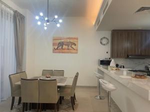 a kitchen and dining room with a table and chairs at Villa Elena Hayat Island Marbella in Ras al Khaimah