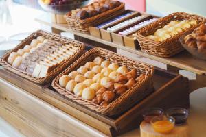 a buffet with baskets of bread and other pastries at Hotel Intergate Kanazawa in Kanazawa
