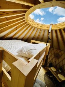 un letto in legno in una camera con finestra rotonda di Magnolia Hoeve - overnachten in de natuur op een paarden resort 