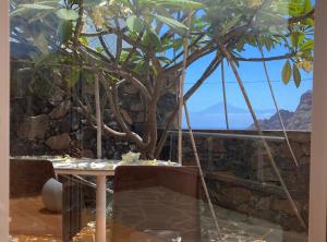 a table and chairs with a tree in a room at Casa Julietta in Hermigua