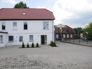 Casa blanca con techo rojo en una entrada de ladrillo en MOONROOMS Cityapartment 2 in Bad Bevensen, en Bad Bevensen