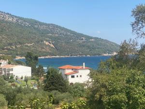 a house on a hill next to a body of water at Blue Bay Beach Hotel in Koinyra