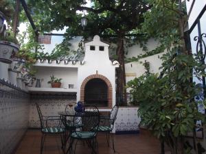 un patio con mesa, sillas y chimenea en Casa Luciíta: Agradable con chimenea, patio y BBQ., en Ojén