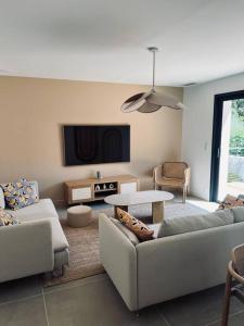 ein Wohnzimmer mit zwei Sofas und einem Fernseher in der Unterkunft Villa Azur in La Valette-du-Var