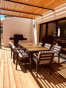 einen Holztisch und Stühle auf einer Terrasse mit einem Klavier in der Unterkunft Villa Azur in La Valette-du-Var