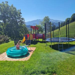 un perro está sentado en una piscina en la hierba en Brandhof 