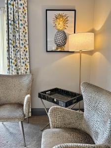 uma sala de estar com duas cadeiras e uma mesa com um ananás em Grange Farm Park em Alford