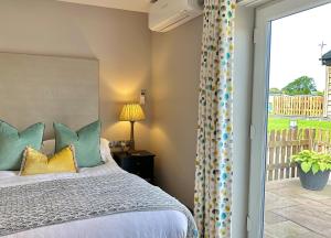 AlfordにあるGrange Farm Parkのベッドルーム1室(ベッド1台付)、スライド式ガラスドアが備わります。