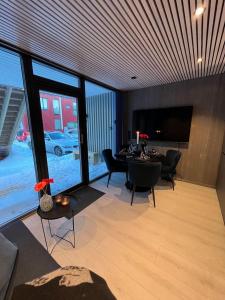 un soggiorno con tavolo, sedie e TV di New and modern apartment in Henningsvær a Henningsvær