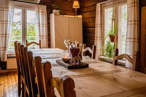 uma sala de jantar com uma mesa de madeira e janelas em Kotatuli Forest Lodge em Rovaniemi