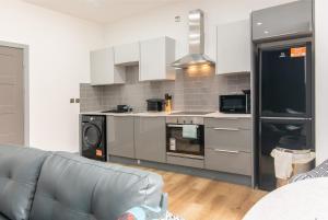 a living room with a couch and a kitchen at Charnwood Flat 2 - 3BR Derby City Centre Flat in Derby