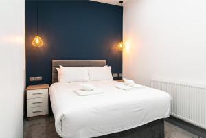 1 dormitorio con 1 cama blanca grande y 2 toallas en Charnwood Flat 2 - 3BR Derby City Centre Flat en Derby