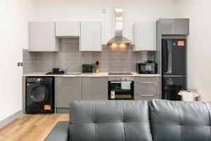 a living room with a couch and a kitchen at Charnwood Flat 2 - 3BR Derby City Centre Flat in Derby