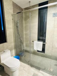 a bathroom with a toilet and a glass shower at Sentral Suites KualaLumpur in Kuala Lumpur