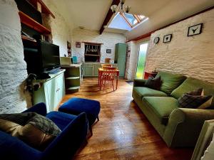 a living room with a couch and a tv at The Horseshoe in Lochgilphead