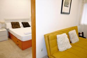 - une chambre avec un lit avec un miroir et un canapé jaune dans l'établissement Homenfun Barcelona Sagrada Familia Lepanto, à Barcelone