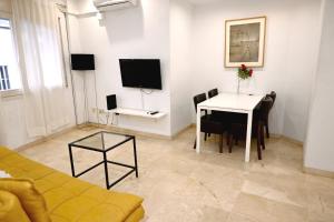 - un salon avec une table et une télévision dans l'établissement Homenfun Barcelona Sagrada Familia Lepanto, à Barcelone