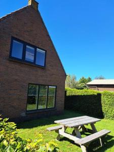 een picknicktafel voor een bakstenen gebouw bij Family House Wakker in Eemnes