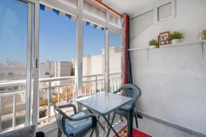 een tafel en stoelen in een kamer met een raam bij Apartamento de Raa in Torrevieja