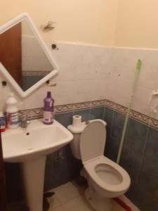 a bathroom with a toilet and a sink and a mirror at Appartement Sidi Maarouf in Casablanca