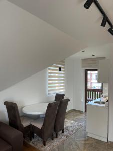 a dining room with a white table and chairs at Apartmani Ristanović in Zlatibor