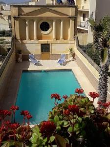 a swimming pool in front of a house at Villa Palma in Sannat