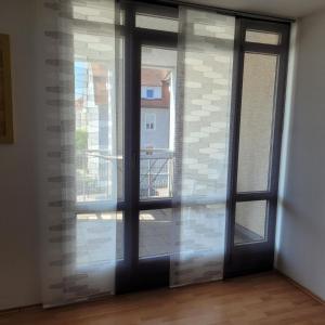 eine offene Glastür mit Blick auf ein Gebäude in der Unterkunft Ludwigsturm Appartement in Straubing in Straubing