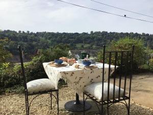 Linden Retreat في Brimscombe: طاولة مع كرسيين وطاولة مع قطعة قماش