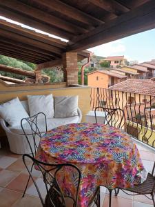 a patio with a table and chairs on a balcony at La Villa Tanca Piras in Nebida